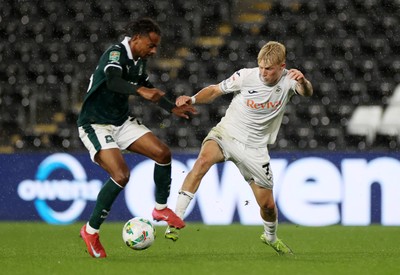 260825 - Swansea City v Plymouth Argyle - Carabao Cup - Melker Widell of Swansea City is tackled by Freddie Issaka of Plymouth Argyle 
