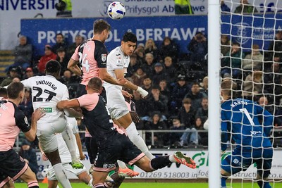 221025 - Swansea City v Queens Park Rangers - Sky Bet Championship - Nicolas Madsen of Queens Park Rangers challenges for the aerial ball with Marko Stamenic of Swansea City