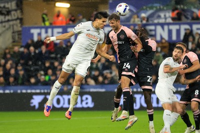 221025 - Swansea City v Queens Park Rangers - Sky Bet Championship - Marko Stamenic of Swansea City challenges for the aerial ball with Nicolas Madsen of Queens Park Rangers
