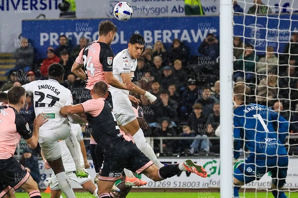 221025 - Swansea City v Queens Park Rangers - Sky Bet Championship - Nicolas Madsen of Queens Park Rangers challenges for the aerial ball with Marko Stamenic of Swansea City