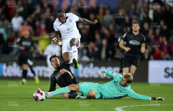 181022 - Swansea City v Reading - SkyBet Championship - Michael Obafemi of Swansea City jumps over the incoming tackles of Tom McIntyre and Joe Lumley of Reading