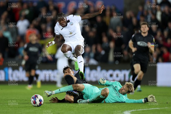 181022 - Swansea City v Reading - SkyBet Championship - Michael Obafemi of Swansea City jumps over the incoming tackles of Tom McIntyre and Joe Lumley of Reading