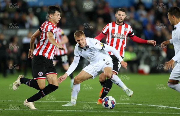 130922 - Swansea City v Sheffield United - SkyBet Championship - Jay Fulton of Swansea City is challenged by Anel Ahmedhodzic and Oliver Norwood of Sheffield United