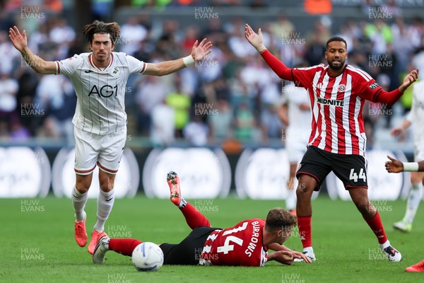 220826 - Swansea City v Sheffield United - Sky Bet Championship - Jaïro Riedewald of Sheffield United (R) and Josh Key of Swansea City react to a foul on Harrison Burrows of Sheffield United (C) 