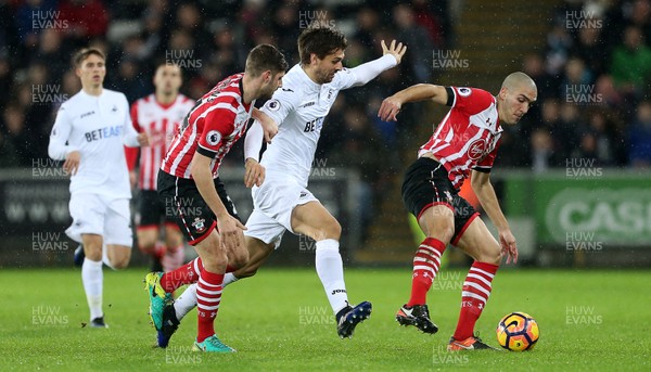 310117 - Swansea City v Southampton - Premier League - Fernando Llorente of Swansea City is tackled by Oriol Romeu of Southampton