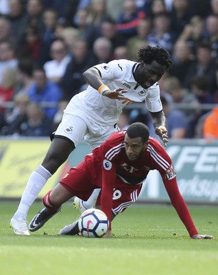 230917 - Swansea City v Watford, Premier League - Wilfried Bony of Swansea City tangles with Etienne Capoue of Watford as they compete for the ball