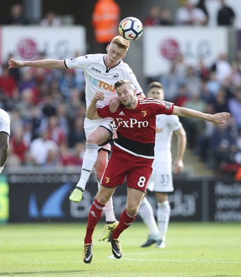 230917 - Swansea City v Watford, Premier League - Sam Clucas of Swansea City challenges Tom Cleverley of Watford for the ball