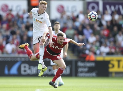 230917 - Swansea City v Watford, Premier League - Sam Clucas of Swansea City challenges Tom Cleverley of Watford for the ball