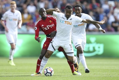 230917 - Swansea City v Watford, Premier League - Jordan Ayew of Swansea City and Abdoulaye Doucoure of Watford compete for the ball