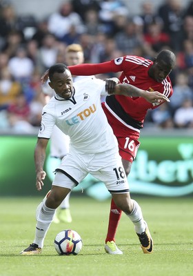 230917 - Swansea City v Watford, Premier League - Jordan Ayew of Swansea City and Abdoulaye Doucoure of Watford compete for the ball