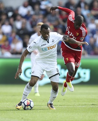 230917 - Swansea City v Watford, Premier League - Jordan Ayew of Swansea City and Abdoulaye Doucoure of Watford compete for the ball