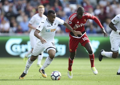 230917 - Swansea City v Watford, Premier League - Jordan Ayew of Swansea City and Abdoulaye Doucoure of Watford compete for the ball