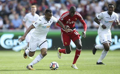 230917 - Swansea City v Watford, Premier League - Jordan Ayew of Swansea City and Abdoulaye Doucoure of Watford compete for the ball