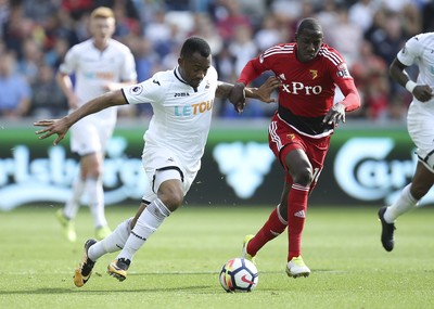 230917 - Swansea City v Watford, Premier League - Jordan Ayew of Swansea City and Abdoulaye Doucoure of Watford compete for the ball