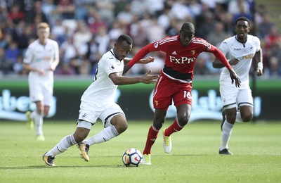 230917 - Swansea City v Watford, Premier League - Jordan Ayew of Swansea City and Abdoulaye Doucoure of Watford compete for the ball