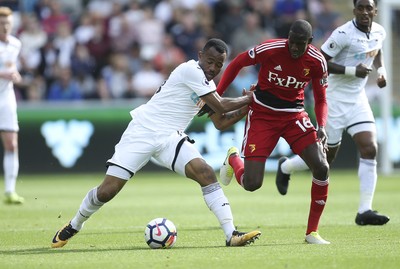 230917 - Swansea City v Watford, Premier League - Jordan Ayew of Swansea City and Abdoulaye Doucoure of Watford compete for the ball