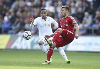 230917 - Swansea City v Watford, Premier League - Kiko Femenia of Watford clears as Martin Olsson of Swansea City closes in