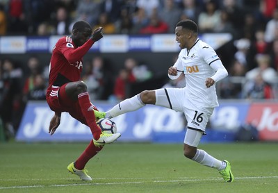 230917 - Swansea City v Watford, Premier League - Martin Olsson of Swansea City challenges Abdoulaye Doucoure of Watford for the ball