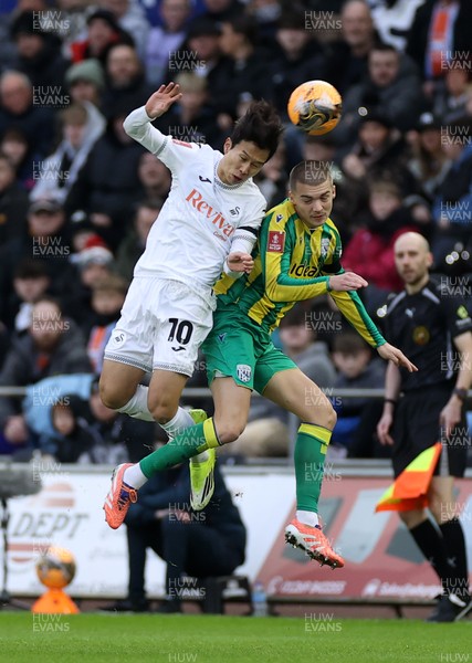 110126 - Swansea City v West Bromwich Albion - FA Cup Third Round - Eom Ji-Sung of Swansea City and Alfie Gilchrist of West Brom go up for the ball
