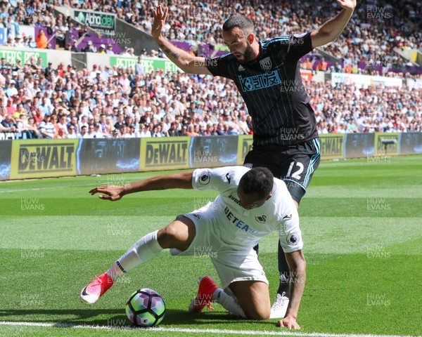 210517 - Swansea City v West Bromwich Albion, Premier League -Jordan Ayew of Swansea City is challenged by Marc Wilson of West Bromwich Albion