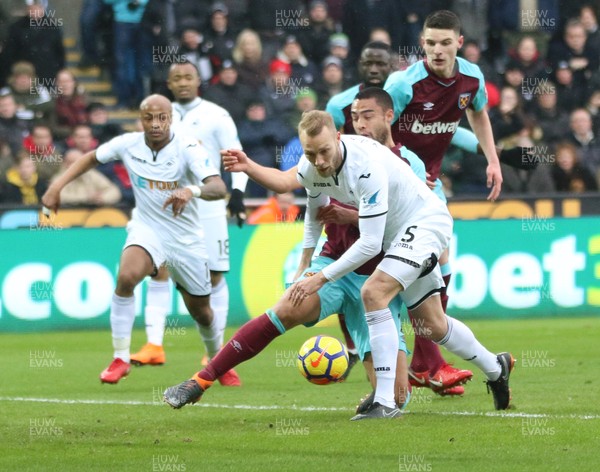 030318 - Swansea City v West Ham United, Premier League - Mike van der Hoorn of Swansea City and Winston Reid of West Ham United clash as they look to win the ball