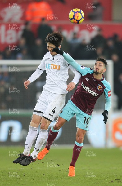 030318 - Swansea City v West Ham United, Premier League - Ki Sung Yueng of Swansea City competes with Manuel Lanzini of West Ham United to win the ball