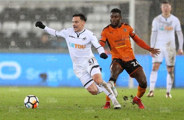 170118 - Swansea City v Wolverhampton Wanderers - FA Cup Replay - Roque Mesa of Swansea City is tackled by Bright Enobakhare of Wolverhampton Wanderers