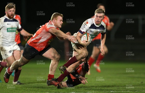 110117 - Swansea RFC v Llanelli RFC - Fosters Cup - Ewan Gully of Swansea is tackled by Tom Howell of Llanelli by Chris Fairweather/Huw Evans Agency