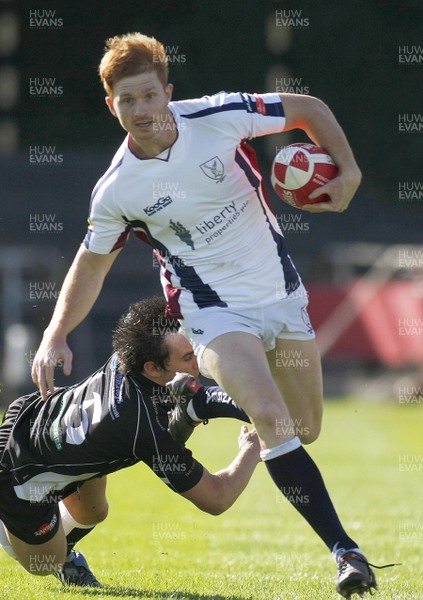 25.09.10 Swansea RFC v Cross Keys RFC - Principality Premiership - Swansea's James Dixon bursts through the tackle of Cross Keys' Ryan Lee. 