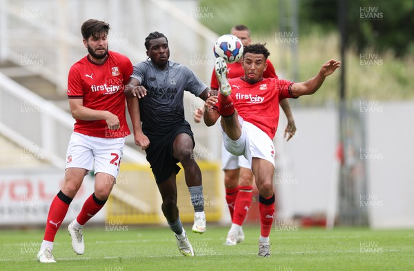 230722 - Swindon Town v Cardiff City, Pre-season Friendly - Remeao Hutton of Swindon Town clears as Sheyi Ojo of Cardiff City closes in