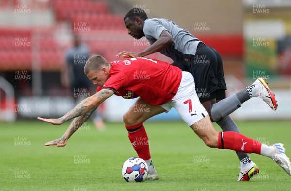 230722 - Swindon Town v Cardiff City, Pre-season Friendly - Jamilu Collins of Cardiff City and Ben Gladwin of Swindon Town tangle as they compete for the ball