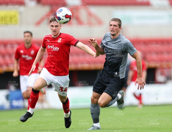 230722 - Swindon Town v Cardiff City, Pre-season Friendly - Max Watters of Cardiff City and Ciaran Brennan of Swindon Town look to win the ball