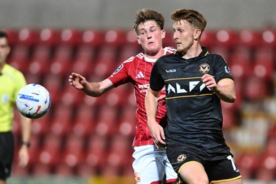 220926 - Swindon Town v Newport County - EFL Trophy -  Ged Garner of Newport County is challenged by Freddie Hoare of Swindon