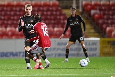 220926 - Swindon Town v Newport County - EFL Trophy -  Cole Jarvis of Newport County is challenged by James Debayo of Swindon