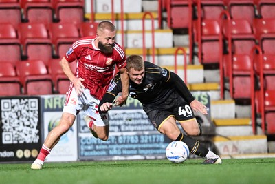 220926 - Swindon Town v Newport County - EFL Trophy -  Cole Jarvis of Newport County is challenged by Dan Butler of Swindon