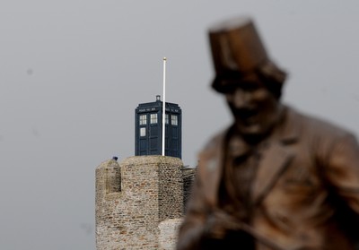 091209 - Doctor Who Filming - The Tardis sits on the tower at Caerphilly Castle, South Wales, near the statue of comedian Tommy Cooper who was born in the town