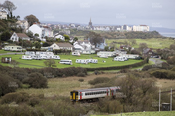 051020 - Picture shows a train passing the seaside town of Tenby, West Wales with a caravan and campsite in the foreground Welsh Health Minister Vaughan Gething today said the Welsh Government are considering imposing travel restrictions on coronavirus hotspots, which could stop travel to Wales from areas like the North East of England