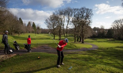 130321 Golf returns in Wales - One of the first players to take to the course plays a shot at Cardiff Golf Club on the day that lockdown restrictions were eased in Wales for outside sports including golf and tennis