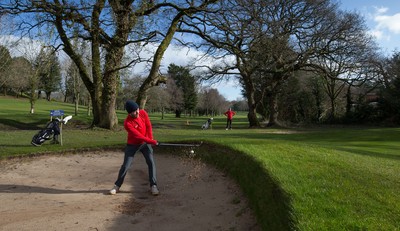 130321 Golf returns in Wales - One of the first players to take to the course plays a shot at Cardiff Golf Club on the day that lockdown restrictions were eased in Wales for outside sports including golf and tennis