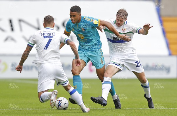 210821 - Tranmere Rovers v Newport County - Sky Bet League 2 - Kieron Morris of Tranmere Rovers and Elliott Nevitt of Tranmere Rovers hold back Priestley Farquharson of Newport County
