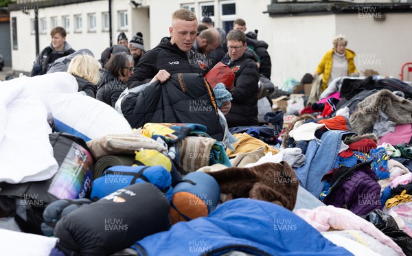070322 Dragons Ben Fry joins along with Dragons and Newport County players and staff helps sort the large number of items donated to help those affected by the conflict in Ukraine