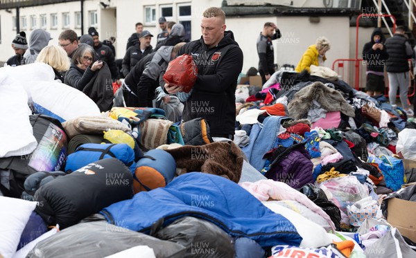 070322 Dragons Ben Fry joins along with Dragons and Newport County players and staff helps sort the large number of items donated to help those affected by the conflict in Ukraine