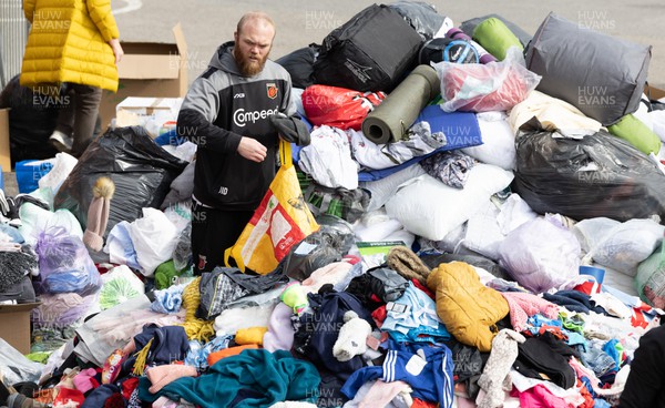 070322 Dragons Joe Davies along with the rest of the Dragons squad and staff join Newport County players and staff to help sort the large number of items donated to help those affected by the conflict in Ukraine
