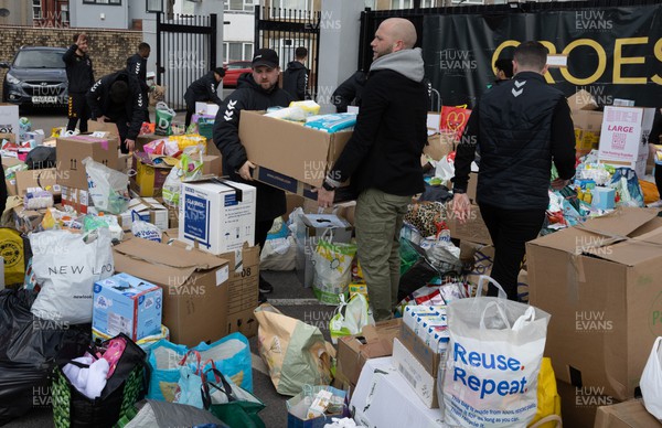 070322 Newport County manager James Rowberry joins the Dragons squad and staff and Newport County players and staff to help sort the large number of items donated to help those affected by the conflict in Ukraine