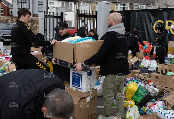070322 Newport County manager James Rowberry joins the Dragons squad and staff and Newport County players and staff to help sort the large number of items donated to help those affected by the conflict in Ukraine