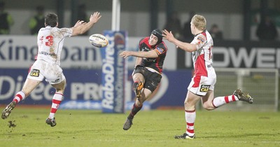 100212 - Ulster v Dragons - RaboDirect Pro 12Dragons' Adam Hughes kicks past Ulster's Ian Whitten and Nevin Spence