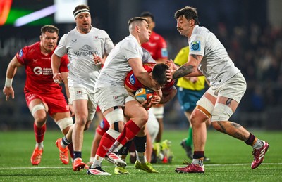 010325 - Ulster v Scarlets - United Rugby Championship - Joe Roberts of Scarlets is tackled by Ulster players James Hume, left, and Matthew Dalton