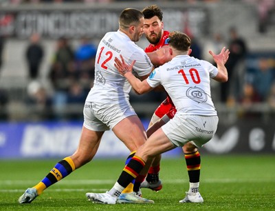 010325 - Ulster v Scarlets - United Rugby Championship - Johnny Williams of Scarlets in action against Ulster players Stuart McCloskey, left, and Jack Murphy