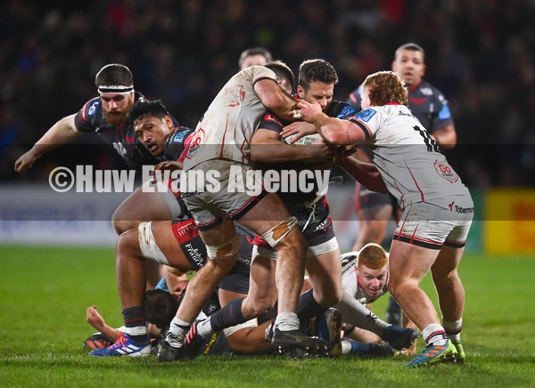 280122 - Ulster v Scarlets - United Rugby Championship - Kieran Hardy of Scarlets is tackled by Alan O'Connor, left, and Brad Roberts of Ulster