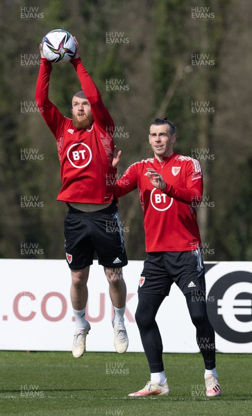 230322 Wales Football Training - Jonny Williams takes the ball as Gareth Bale looks on during a Wales football training session ahead of the World Cup Qualifier play off semi final match against Austria